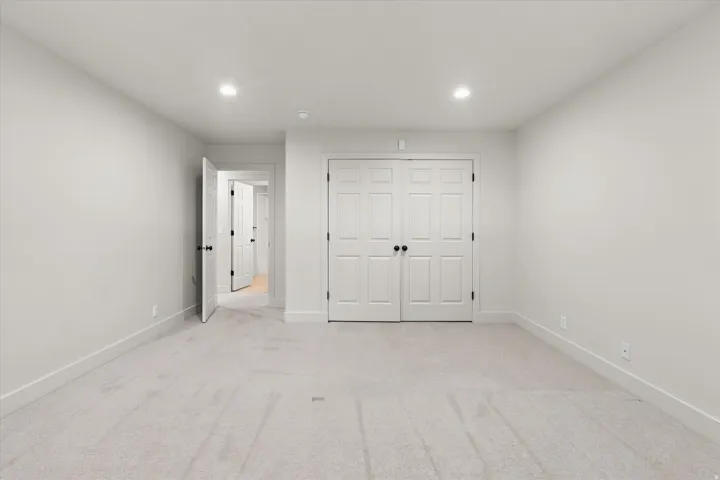 Neutral-toned room featuring light gray carpet flooring and white baseboards
