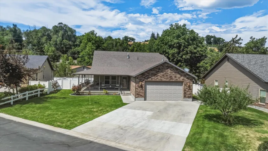 Contemporary residence featuring a brick and siding exterior, an attached garage, and a covered front porch