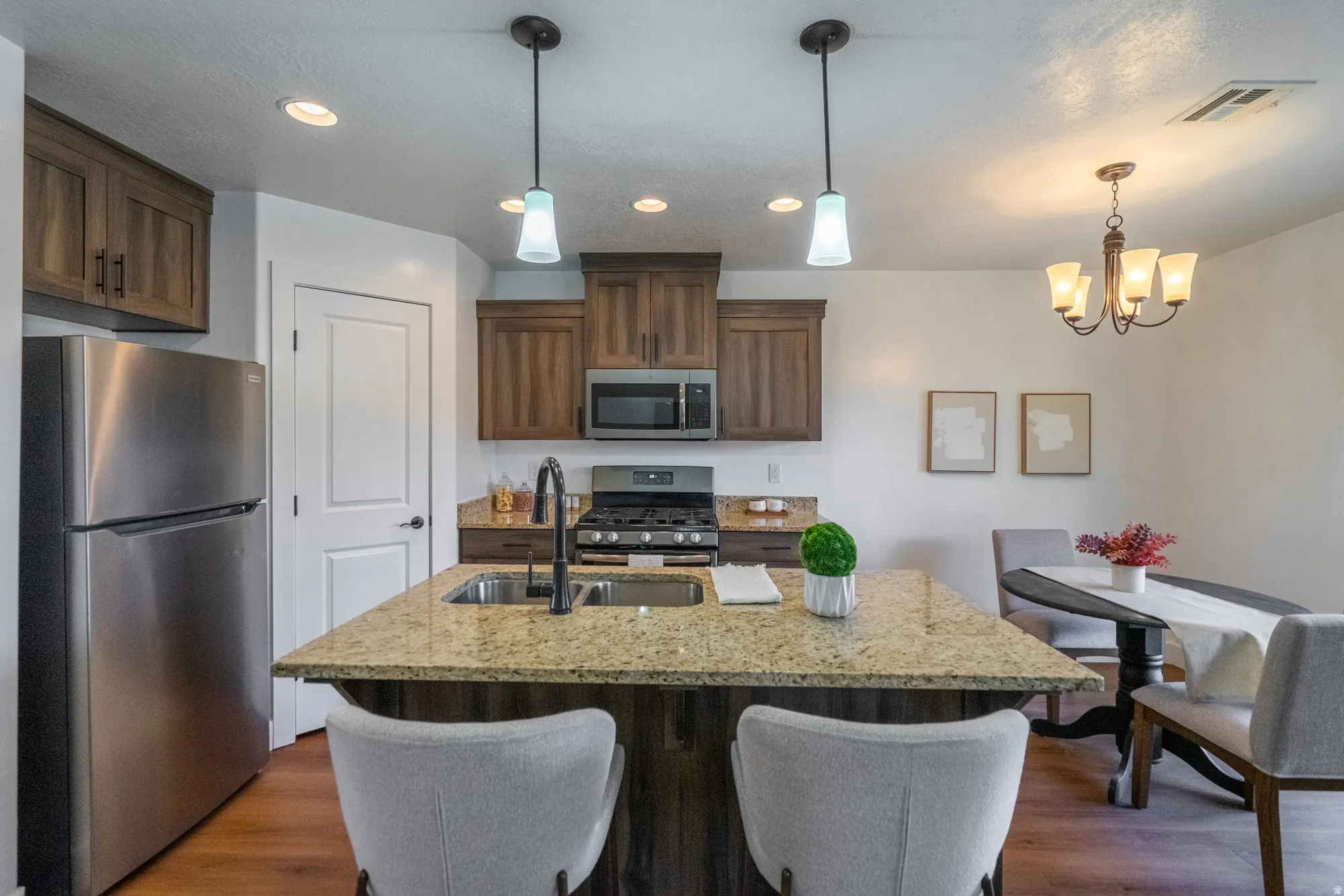 Kitchen with a large island featuring a double-basin sink and a gooseneck faucet