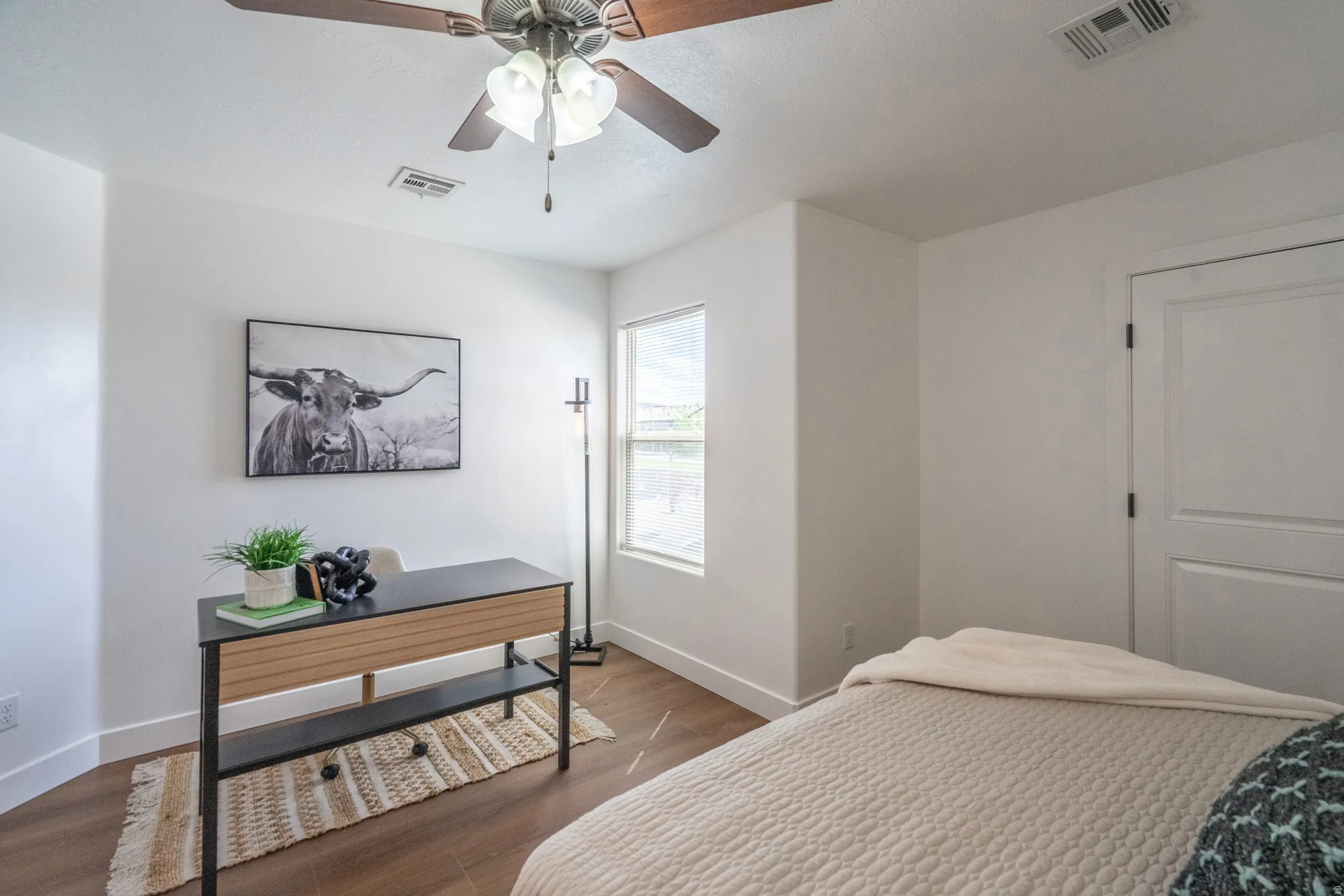 Interior room featuring wood-finish flooring and a ceiling fan with integrated lighting