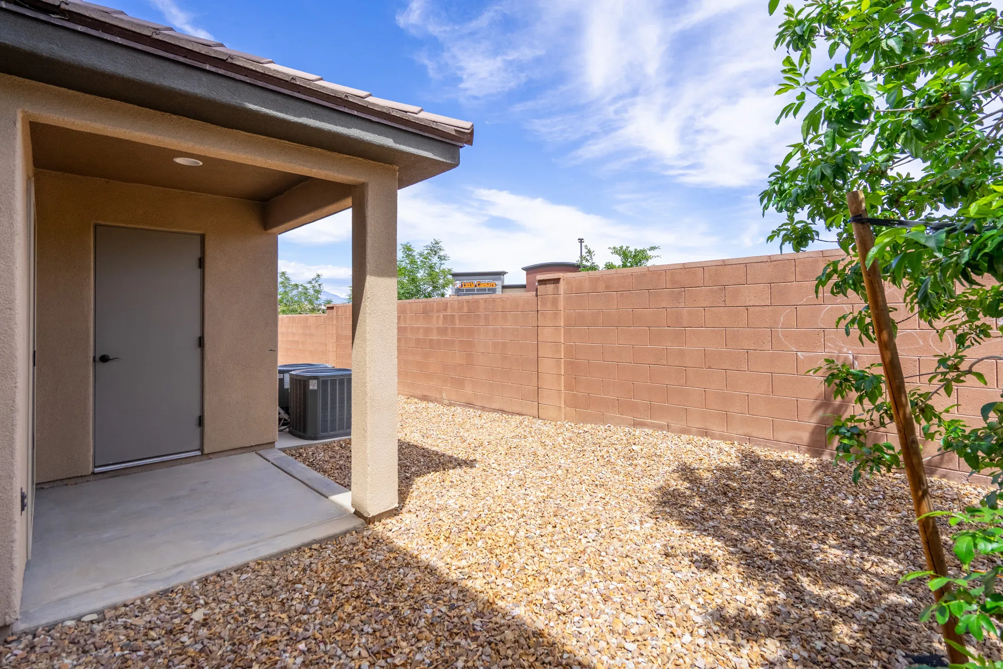 Covered patio with concrete flooring, stucco exterior, and a tile roof overhang