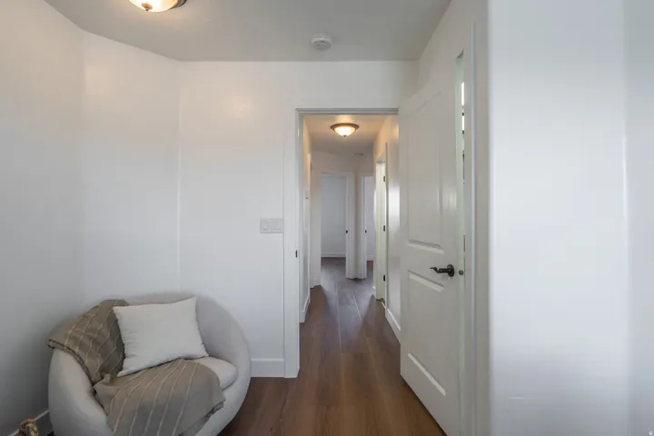 Bright hallway featuring wood-finish flooring, white walls, and recessed lighting fixtures