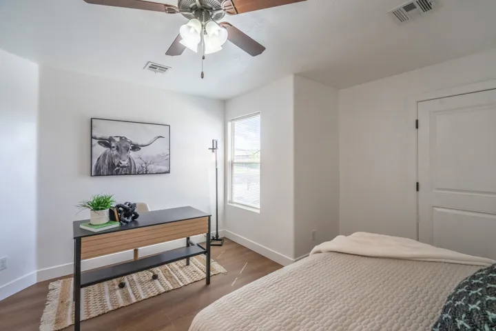 Interior room featuring wood-finish flooring and a ceiling fan with integrated lighting