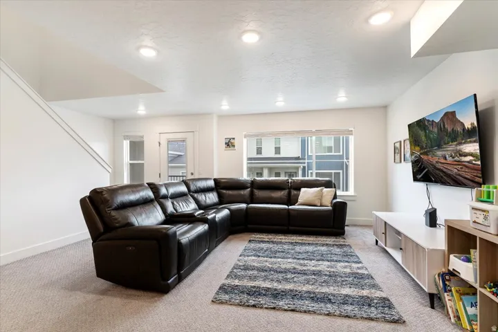 Carpeted living area featuring recessed lighting and a multi-pane window
