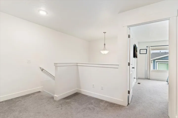 Upper-level landing featuring carpeted flooring and white trimwork