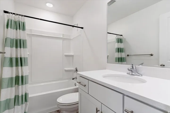 Bathroom featuring a white vanity with an integrated sink, polished chrome faucet, and a large wall-mounted mirror