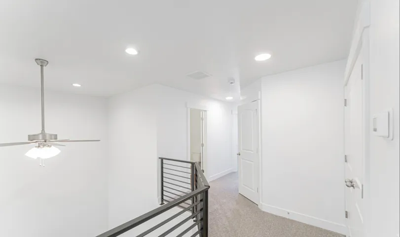 Upper-level landing featuring light gray carpet, recessed lighting, and a contemporary ceiling fan