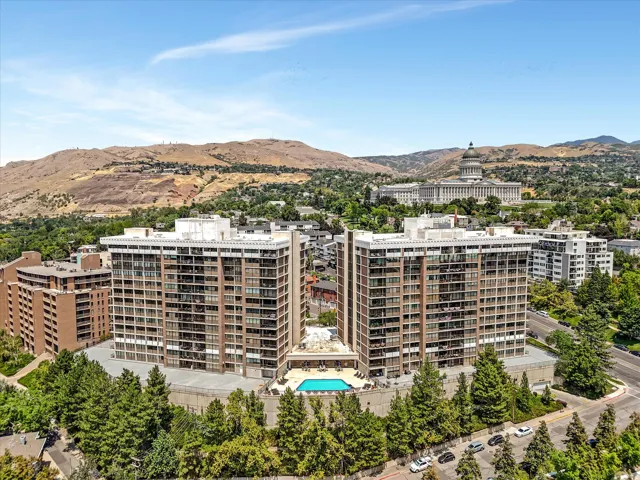 Twin high-rise residential buildings featuring private balconies and an outdoor swimming pool