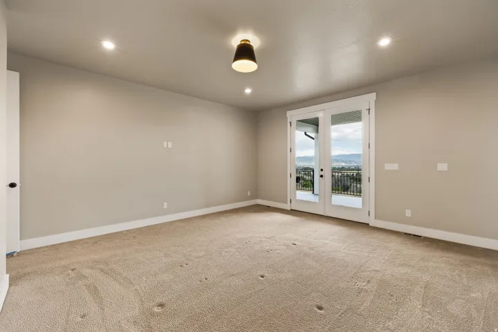 Expansive room featuring light neutral walls, recessed lighting, and a contemporary ceiling fixture