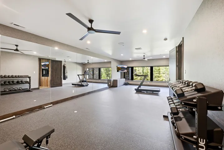 Spacious room featuring full-wall mirrors, recessed lighting, and multiple ceiling fans