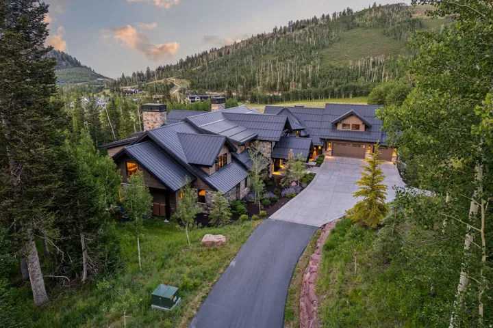 Mountain retreat featuring a stone and wood facade, multiple gables, and a dark metal roof