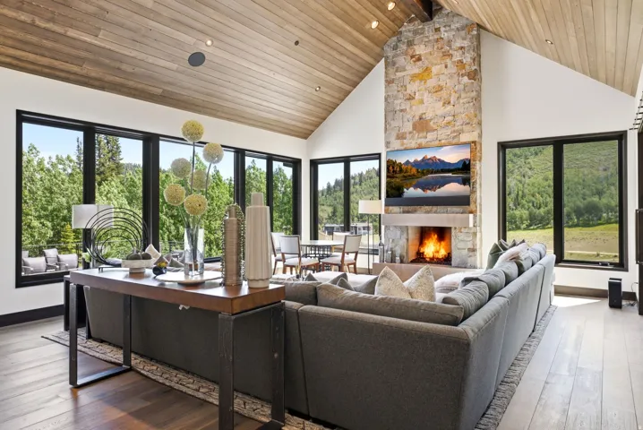 Vaulted wood-finish ceiling complemented by a stone fireplace with hearth