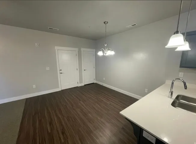 Open-concept area featuring modern wood-finish flooring, a white trim package, and light gray walls