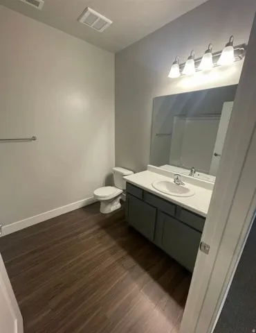 Vanity with integrated sink and chrome faucet, large mirror, and four-light fixture