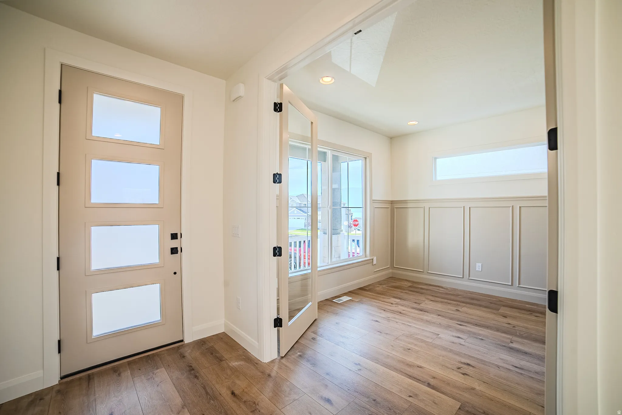 Entryway featuring a contemporary front door with four frosted glass panels and black hardware