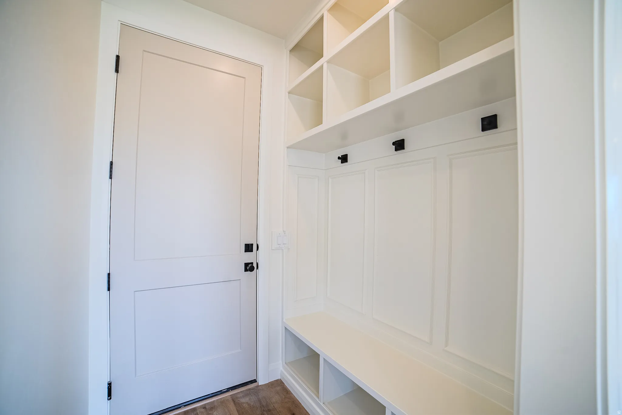Built-in mudroom bench with storage cubbies and upper open shelving