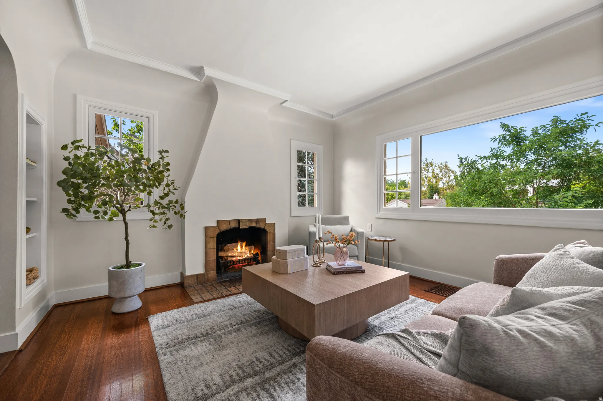 Living area featuring warm wood-finish flooring and a brick fireplace