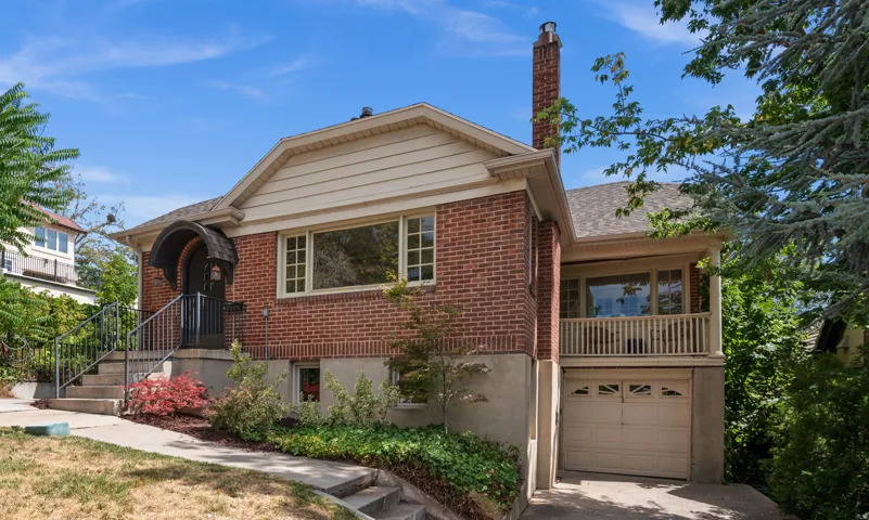 Brick exterior featuring a gabled roof and a prominent brick chimney