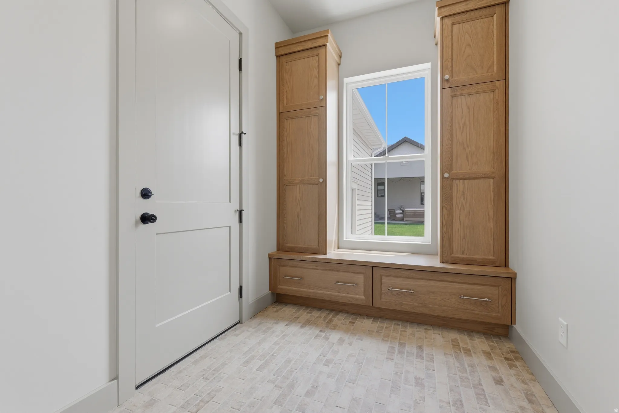 Built-in mudroom bench and storage cabinetry featuring natural wood finishes
