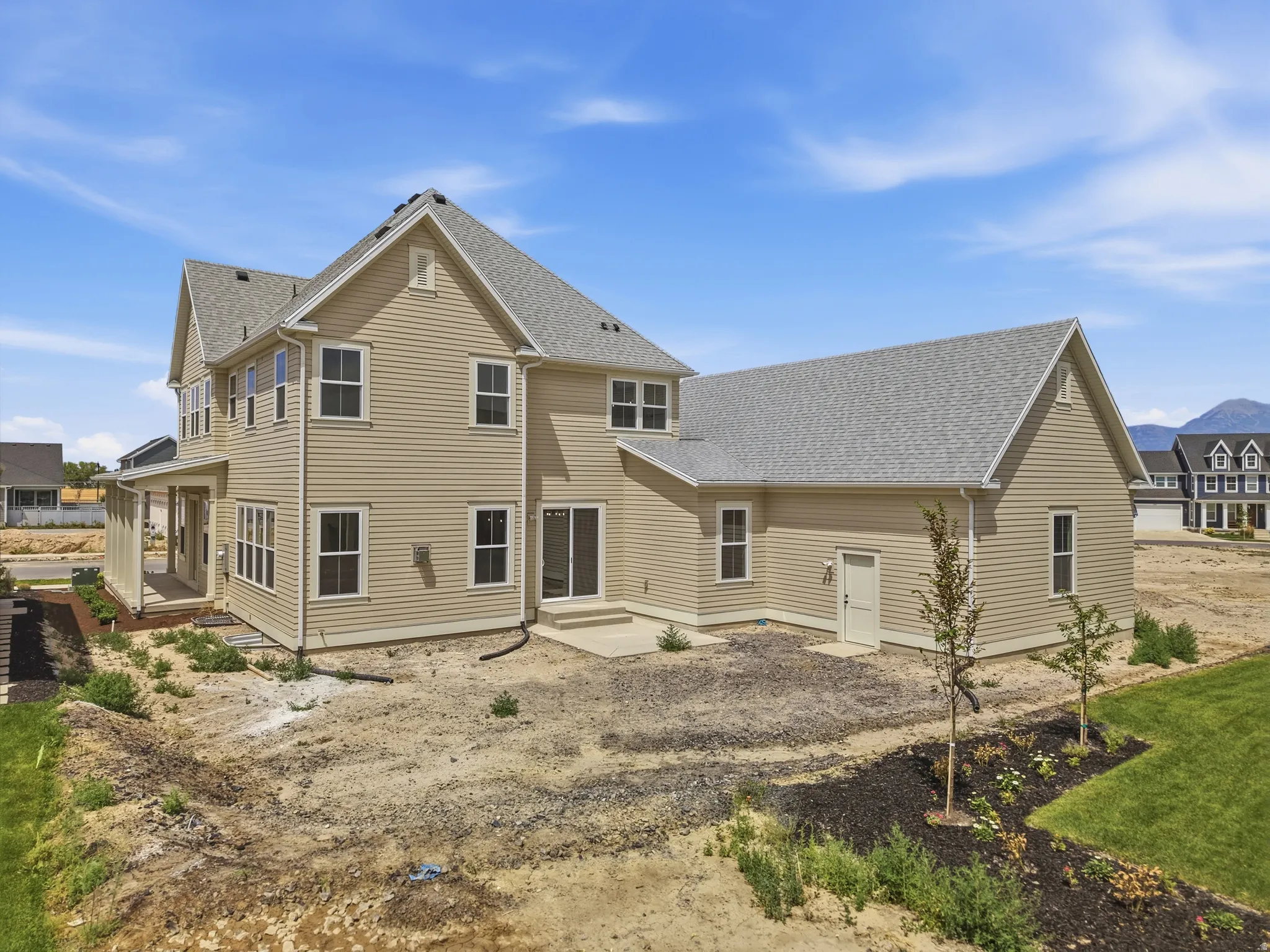 Two-story residence featuring light-toned horizontal siding and a multi-gabled roofline