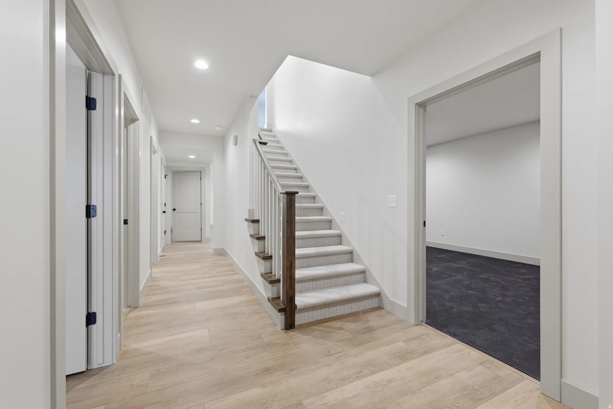 Contemporary hallway featuring wood-finish flooring and recessed lighting