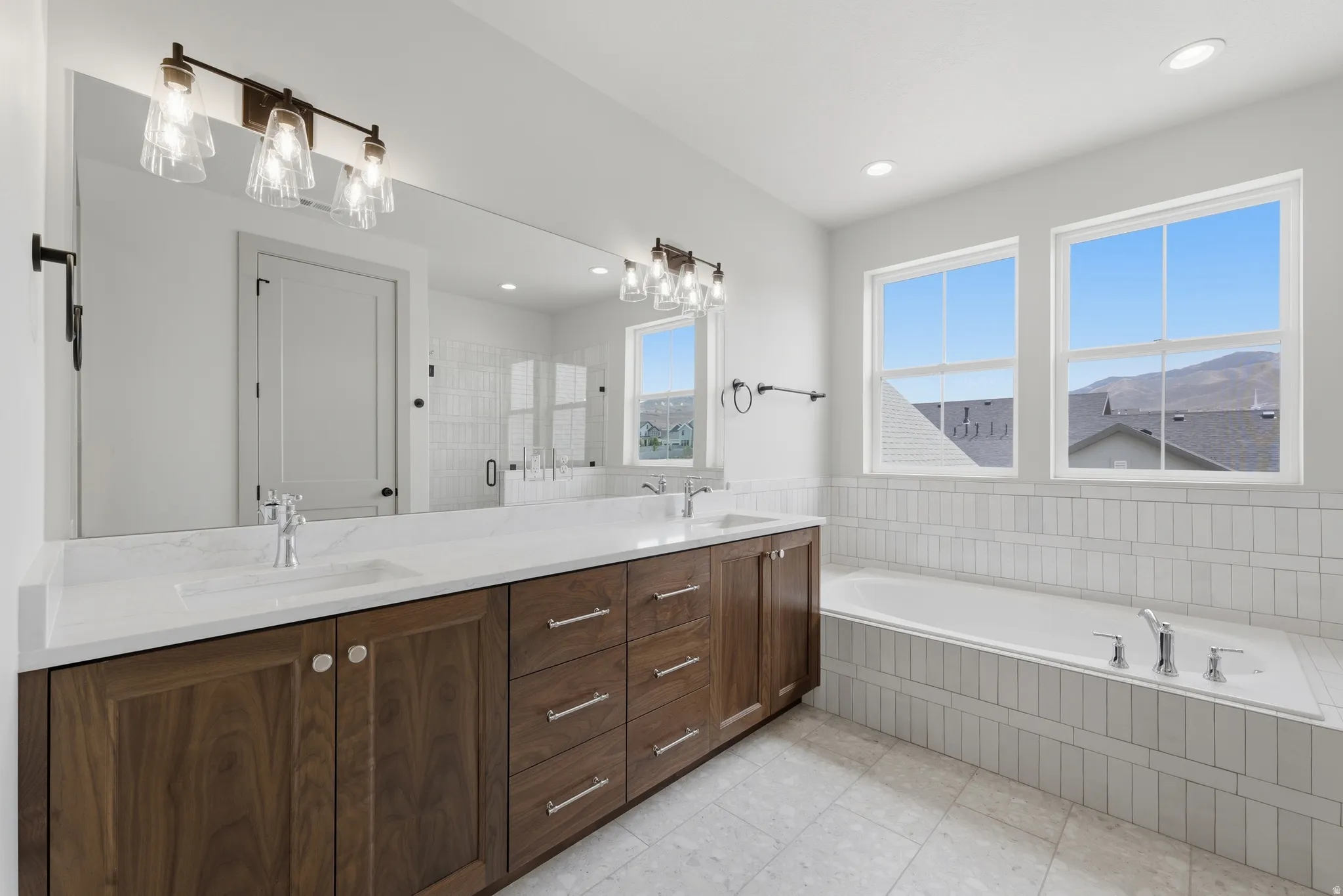 Primary Bathroom.Dual vanity with wood-finish cabinetry, white countertop, and integrated sinks