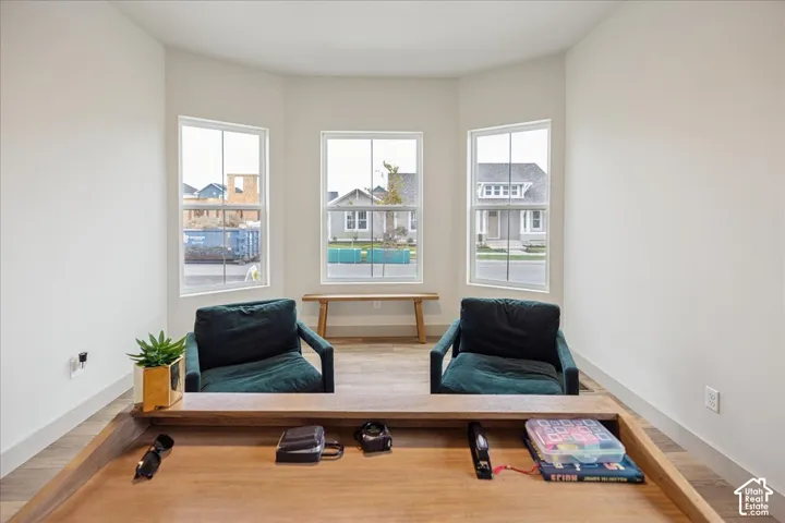 Bay window featuring three paneled windows, wood-finish flooring, and neutral wall color