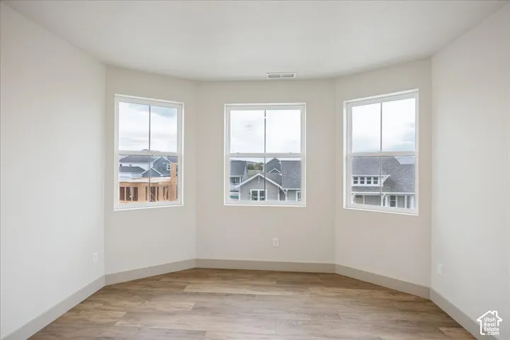Bay window featuring three single-hung windows and wood-finish flooring