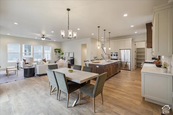 Open-concept kitchen featuring an island with a wood-finish base, stone countertops, stainless steel appliances, and custom cabinetry