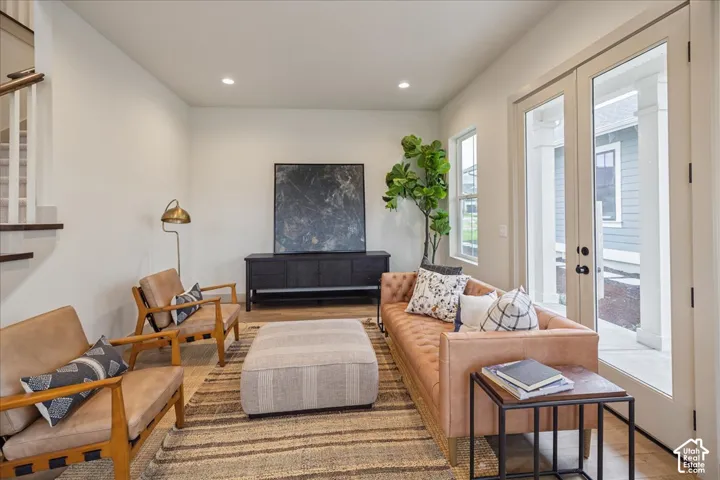 Recessed lighting, wood-finish flooring, and glass-paned double doors with exterior access
