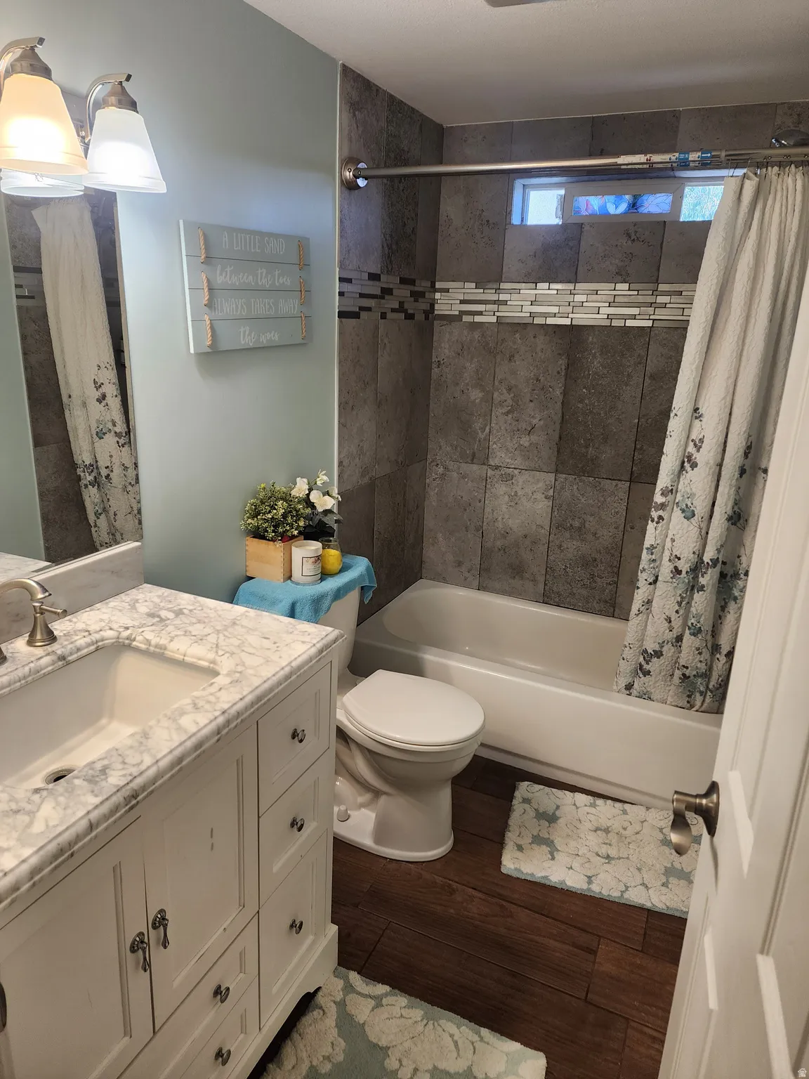 Bathroom featuring a white vanity with a marble-finish countertop, undermount sink, and brushed nickel faucet