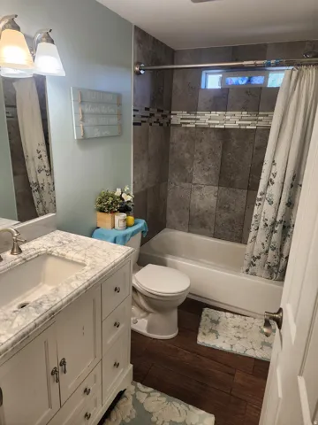 Bathroom featuring a white vanity with a marble-finish countertop, undermount sink, and brushed nickel faucet