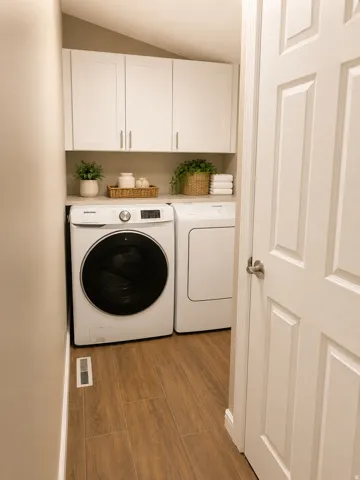 Dedicated laundry area featuring white shaker-style cabinetry, a built-in countertop, and wood-finish flooring