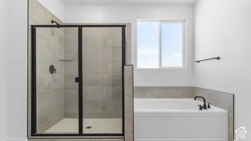 Walk-in shower with clear glass enclosure and matte black hardware