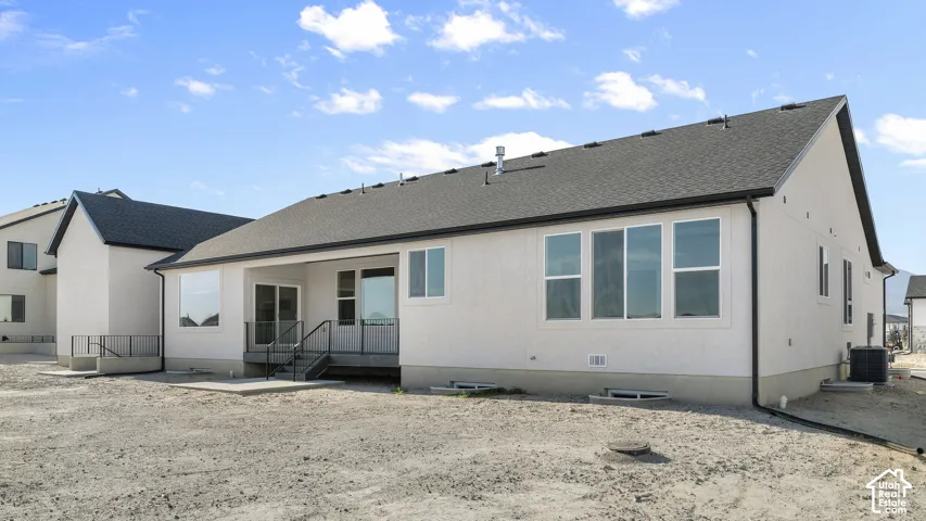White stucco exterior with a dark asphalt shingle roof