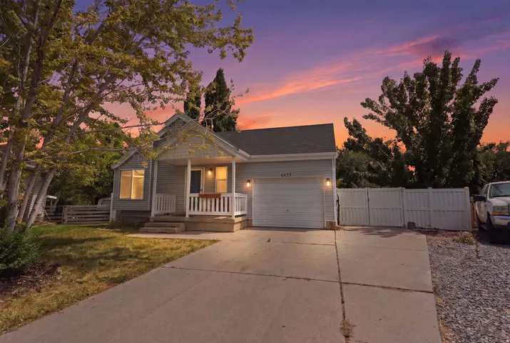 Gray siding exterior with white trim, featuring a covered front porch with white railings, and an attached single-car garage