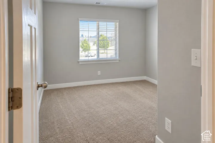 Room featuring light gray walls, plush carpet, and a window with blinds
