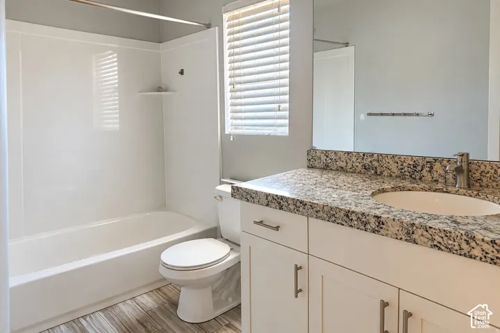 White vanity with brushed nickel hardware, integrated sink, and speckled stone countertop