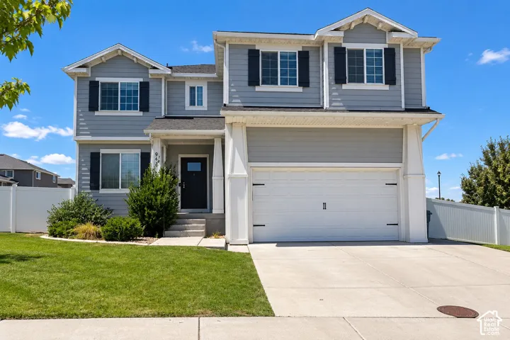 Two-story residence featuring light gray siding, white trim, dark shutters, and an attached two-car garage