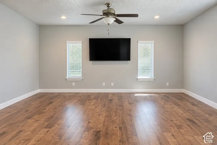 Wood-finish flooring with crisp white trim, recessed lighting, and a ceiling fan