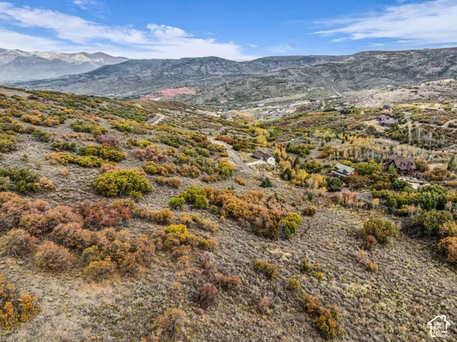 Expansive mountainous terrain with varied ground cover and distant snow-capped peaks