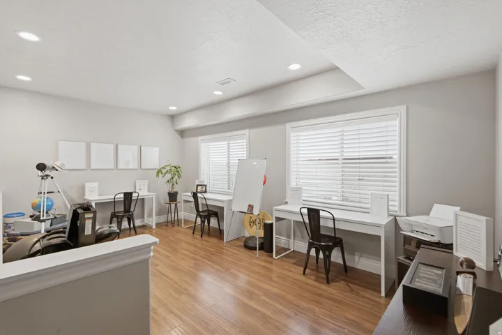 Spacious room featuring wood-finish flooring, recessed lighting, and light-toned walls