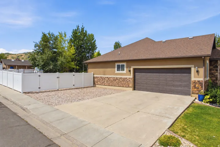 Exterior featuring stucco siding with stone accents and a brown composition shingle roof