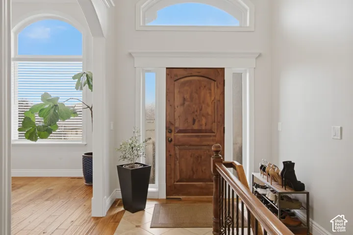 Grand entry with an arched wood door, sidelights, and a transom window