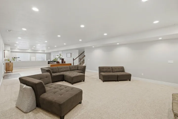 Spacious lower-level living area with recessed lighting, light-toned carpeting, and neutral wall tones