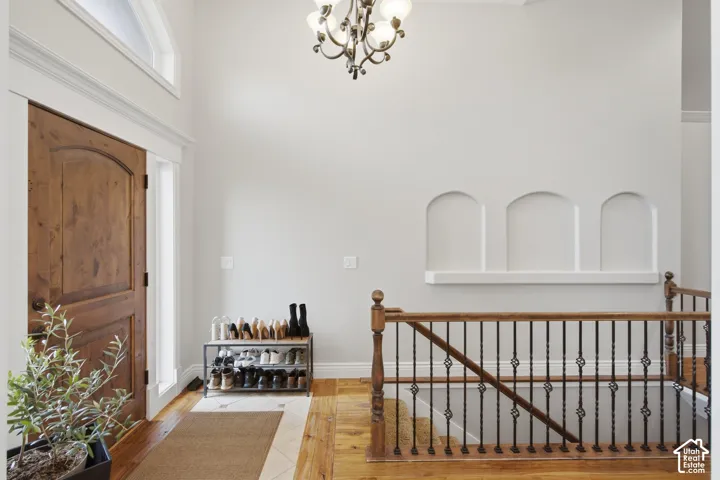 Foyer featuring a solid wood arched entry door with sidelight, transom window, and a decorative chandelier