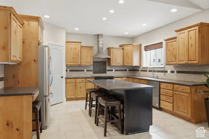 Kitchen featuring light wood cabinetry and a central island with integrated seating