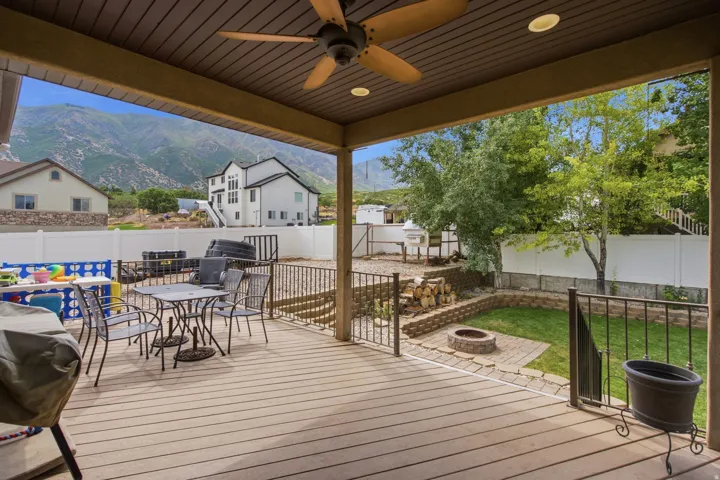 Covered outdoor patio with wood-finish decking and a ceiling fan