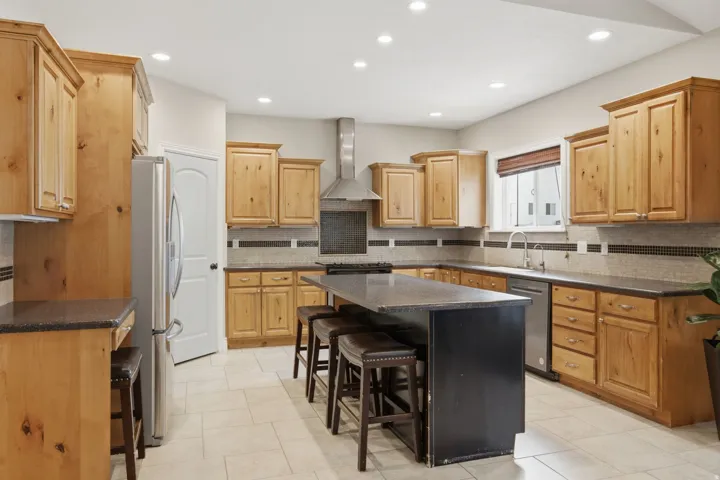 Kitchen featuring light wood cabinetry and a central island with integrated seating