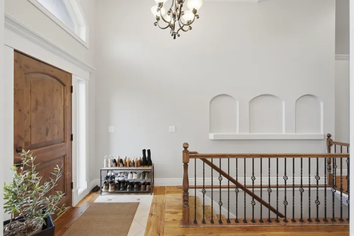 Foyer featuring a solid wood arched entry door with sidelight, transom window, and a decorative chandelier